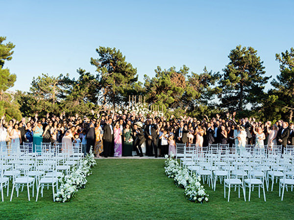 Wide view of Golf Privé Glyfada ceremony lawn with group photo of all guests