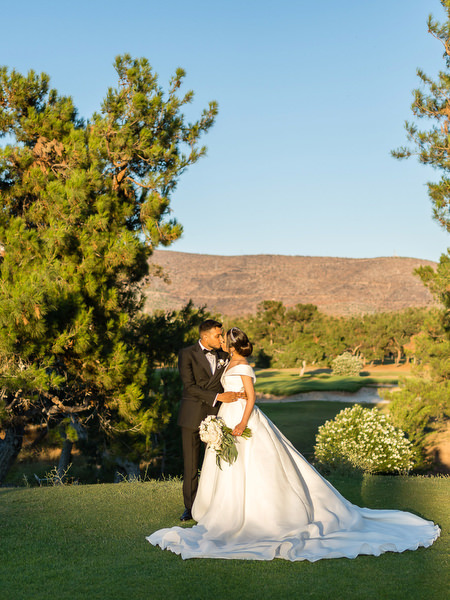 Romantic bride and groom portrait on golf course lawn