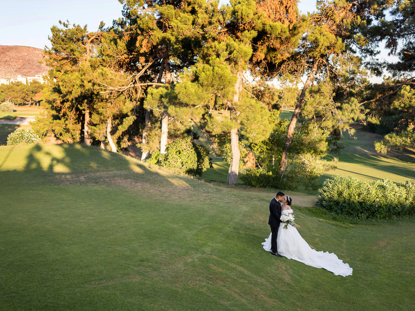 Bride and groom walking through gardens at Golf Privé Glyfada