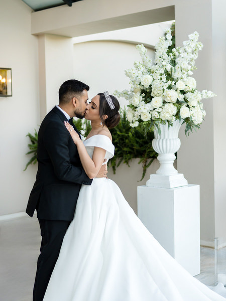 Couple embracing inside ceremony structure at Golf Privé Glyfada