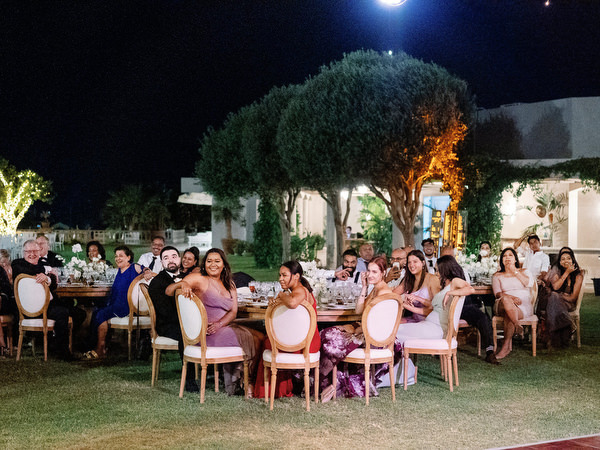 Romantic nighttime wedding decor with floral arch and lighting