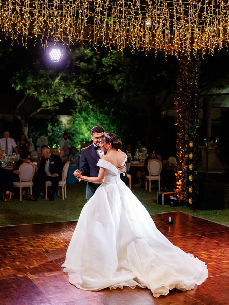 Bride and groom dancing during evening celebration on Athens Riviera