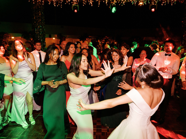 Friends dancing under lights during Athens Riviera wedding party