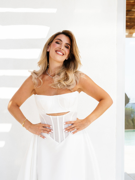 Bride posing confidently on villa steps in modern couture gown overlooking the Athens Riviera