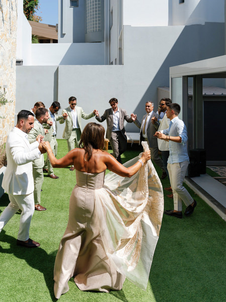 Parents dancing with groomsmen during lively wedding morning at Athens villa