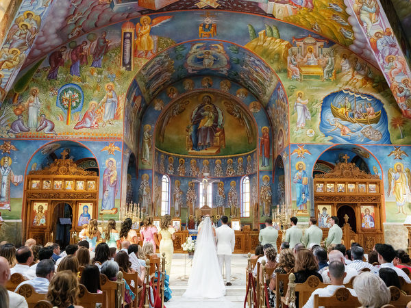 Wide view of ornate Greek Orthodox church interior during luxury Athens wedding ceremony