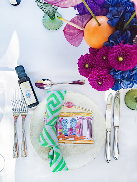 Greek-inspired illustrated menu card with olive oil favor at Athens Riviera wedding reception