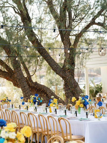 Decorated wedding tables under trees with coastal views on the Athens Riviera