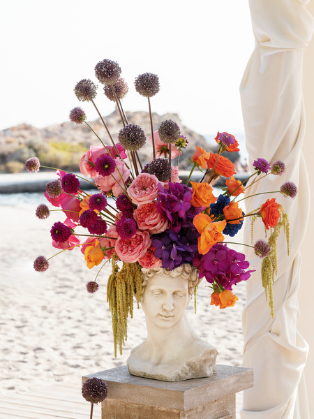 Vibrant Greco-Disco florals arranged in sculptural vase at Athens Riviera seaside wedding