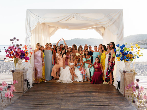 Bride and guests posing beneath seaside ceremony structure during luxury Athens wedding