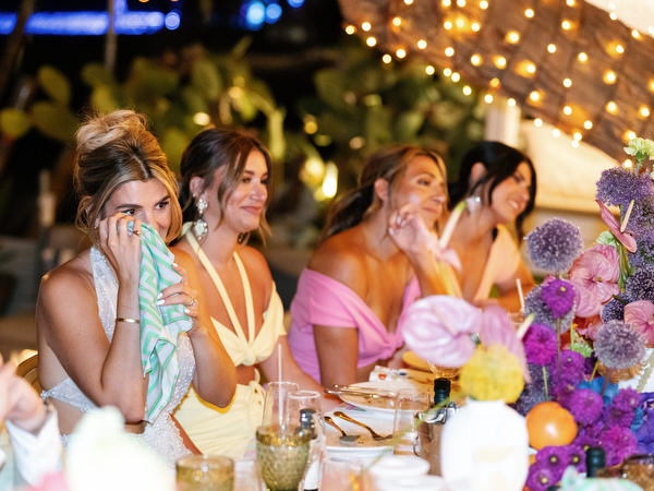 Bridesmaids reacting emotionally during seaside reception speeches in Athens