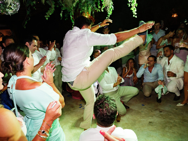 Guest dancing traditional Greek-style wedding dance surrounded by cheering guests
