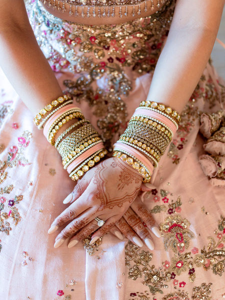 Close-up of bride’s henna hands with gold and pastel bangles at Hindu wedding in Athens Riviera.