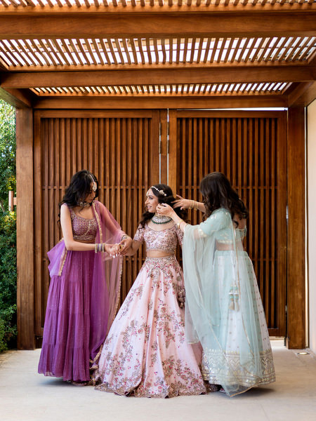 Bride with bridesmaids in ombré lehengas posing at Private House Island Resort Athens Riviera Indian wedding.
