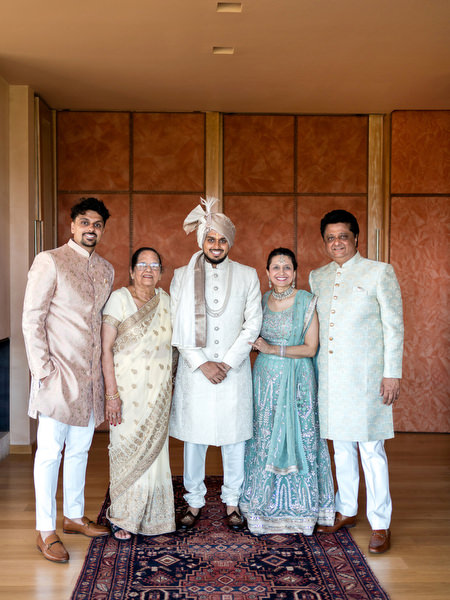 Groom posing with family in pastel sherwanis at colourful Indian wedding at Margi Hotel Athens Riviera.