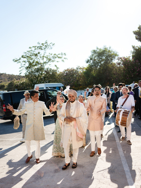 Groom entering with baraat procession and drummers at colourful Indian wedding in Athens Riviera.