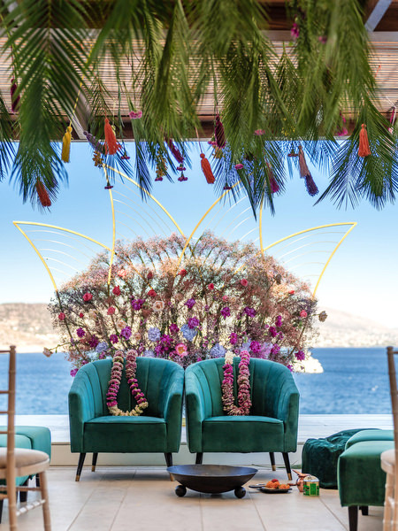 Seaside mandap decorated with pink and purple florals at Private House Island Resort Indian wedding in Athens.