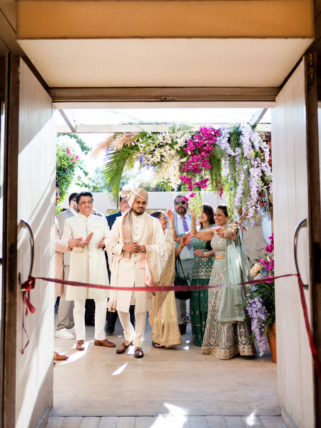 Groom entering Hindu wedding ceremony at Private House Island Resort Athens with family beside him.