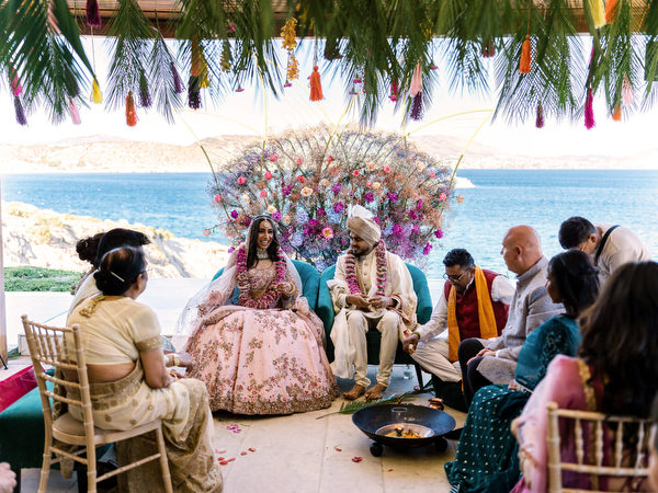Bride and groom seated for Hindu wedding ceremony overlooking the sea at Private House Island Resort Athens.