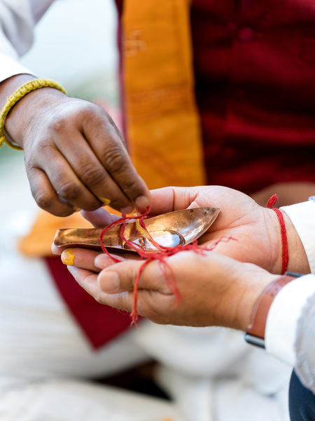 Close-up of hands tying sacred thread during Hindu wedding ceremony at Private House Island Resort Athens.