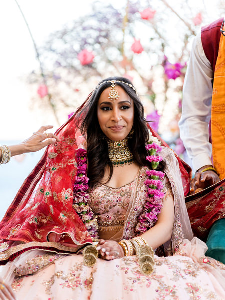 Bride seated under red veil during Hindu wedding ceremony at Private House Island Resort Athens Riviera.