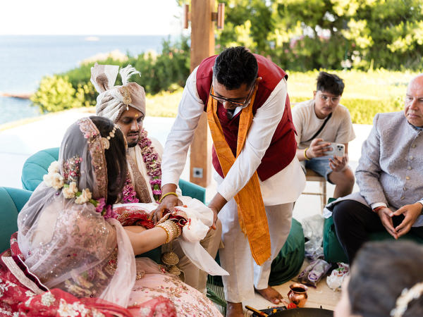 Priest leading Hindu wedding rituals for bride and groom at Private House Island Resort Athens.