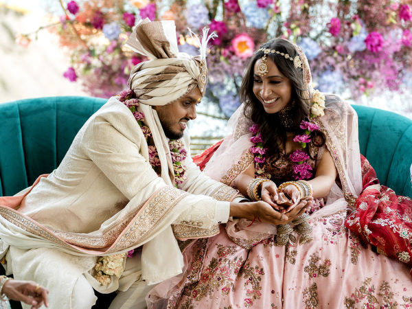 Bride and groom performing pheras around ceremonial fire at colourful Indian wedding in Athens.