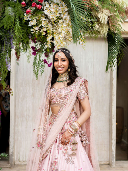 Portrait of bride in embroidered pink lehenga and layered dupatta at Athens destination wedding.