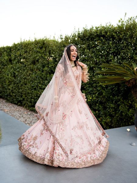 Bride twirling in powder pink floral lehenga at Private House Island Resort Indian wedding in Athens Riviera.
