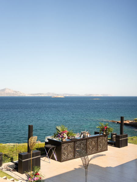 Outdoor cocktail bar overlooking the Aegean Sea at Athens Indian wedding reception.