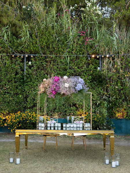 Gold table setup with pastel floral arrangements at Private House Island Resort Indian destination wedding.