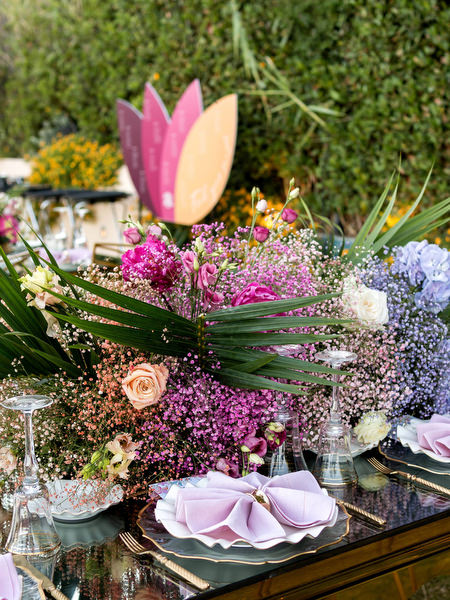 Pink, purple and tropical floral centrepiece on mirrored gold table at Indian wedding in Athens Riviera.