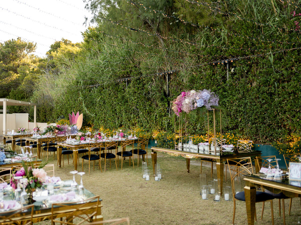 Pink, purple and tropical floral centrepiece on mirrored gold table at Indian wedding in Athens Riviera.