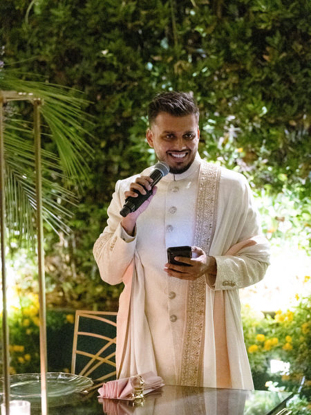 Groom giving speech at outdoor Indian wedding reception in Athens Greece.