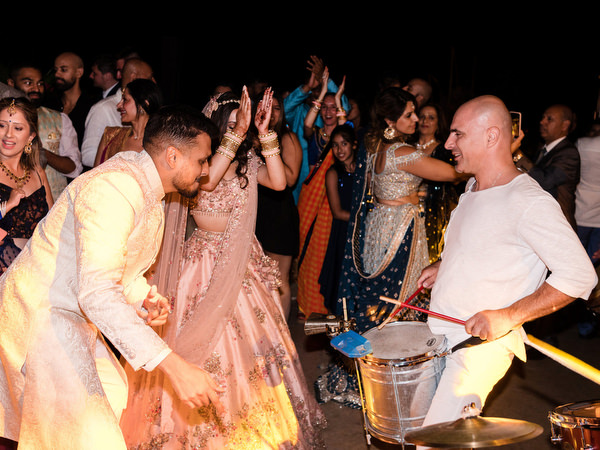High-energy Indian wedding dance floor with live drummer at Private House Island Resort Athens.
