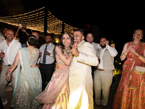 Bride and groom dancing surrounded by cheering guests at Private House Island Resort Athens Indian wedding.