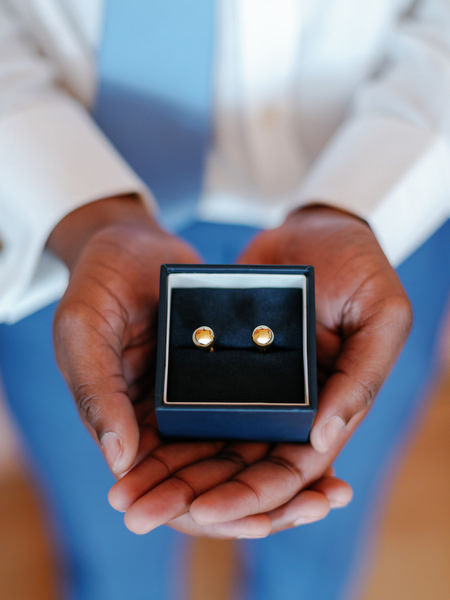 Gold cufflinks detail during groom preparation at luxury Nigerian destination wedding in Athens Greece.