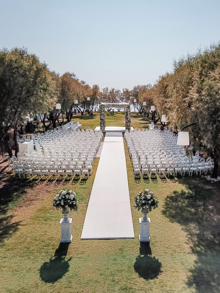 Grand white ceremony aisle with infinity chairs at Ble Azure during luxury Nigerian wedding on the Athens Riviera.