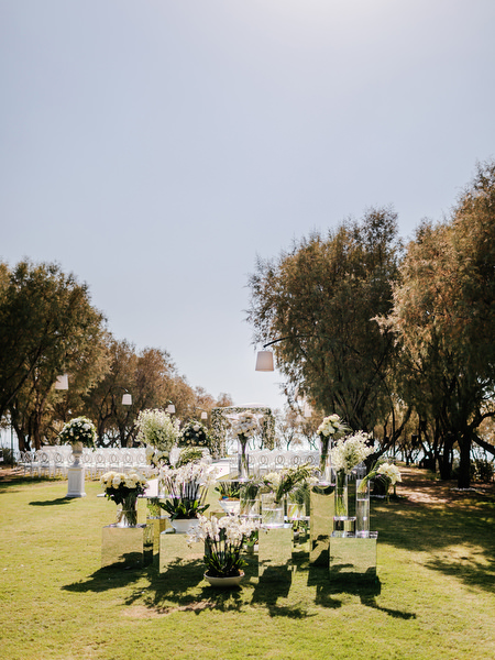 Garden-inspired mirrored ceremony décor with cascading white florals at Ble Azure luxury Nigerian wedding in Athens Greece.