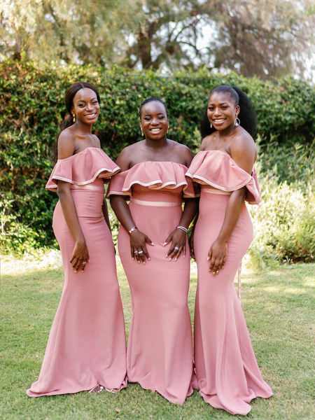 Bridesmaids in matching blush dresses holding bouquets at Ble Azure ceremony for Nigerian destination wedding in Greece.