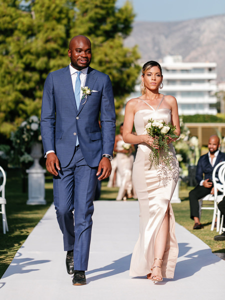 Wedding party walking down white aisle at Ble Azure during 400-guest Nigerian wedding in Athens Greece.