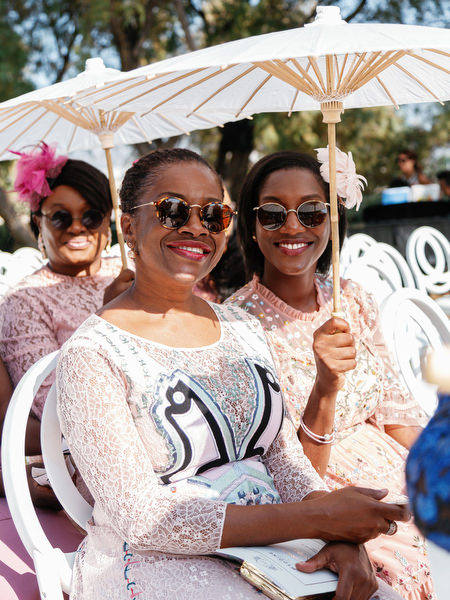 Wedding guests seated under white parasols at Ble Azure ceremony during 400-guest Nigerian wedding in Athens Greece.
