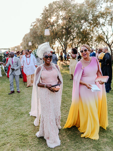 Guests in colorful traditional Nigerian attire during outdoor ceremony reception at Ble Azure Athens Riviera.