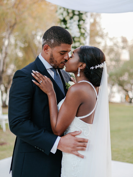 Bride and groom kissing during post-ceremony portraits at Ble Azure luxury Nigerian wedding in Athens Riviera.