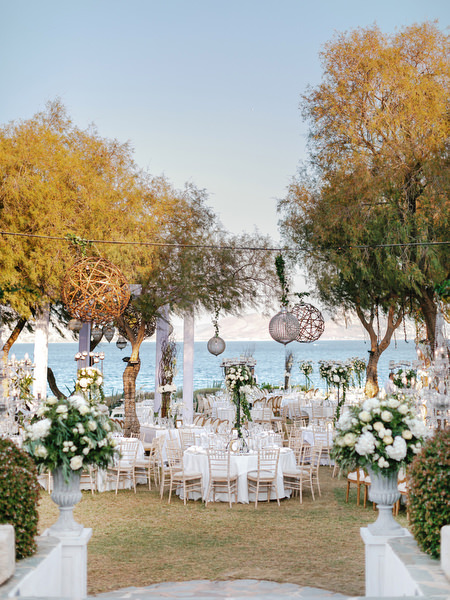 Outdoor reception setup under olive trees at Island Resort The Residence during luxury Nigerian wedding on the Athens Riviera.