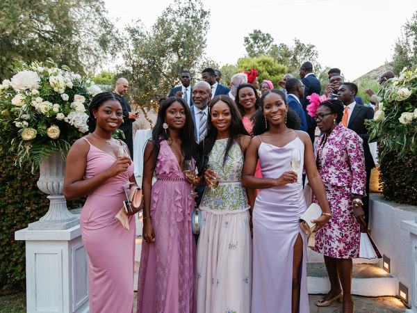 Stylish wedding guests posing during cocktail hour at Island Resort The Residence luxury Nigerian wedding in Athens Riviera.