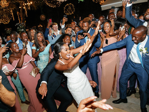 Guests lifting and cheering bride during luxury Nigerian wedding party at Island Resort The Residence Athens.