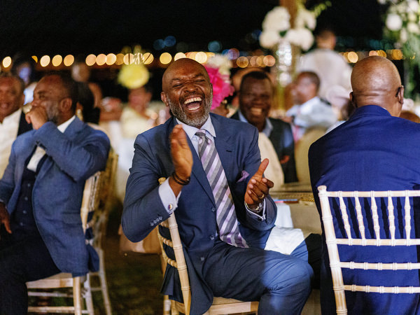 Guest clapping and laughing during reception at Island Resort The Residence luxury Nigerian wedding in Athens.