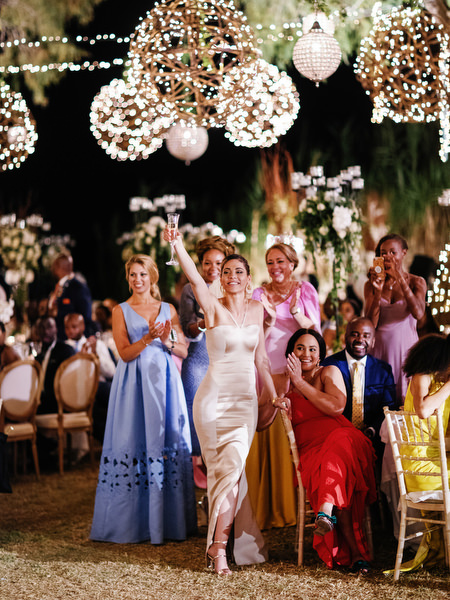 Guests dancing together under chandeliers at Island Resort The Residence Nigerian destination wedding in Greece.