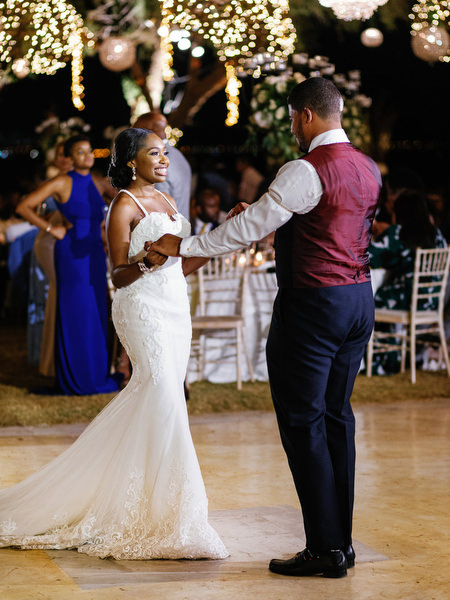Bride and groom sharing first dance under hanging lights at Island Resort The Residence Nigerian wedding in Athens Greece.